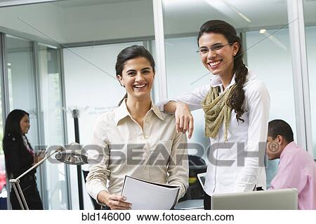 Hispanic businesswomen working together in office View Large Photo Image Stock Image - Hispanic businesswomen working together in office. Fotosearch