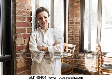 Picture - Hispanic chef leaning against wall in cafe. Fotosearch