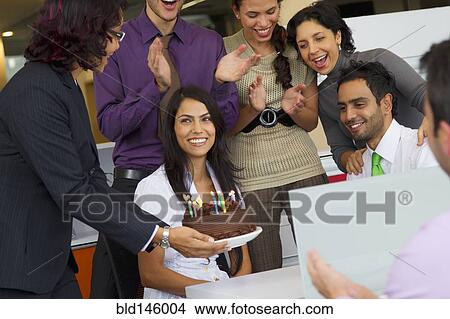 Hispanic co-workers surprising businesswoman with birthday cake View Large Photo Image Picture - Hispanic co-workers surprising businesswoman with birthday cake. Fotosearch