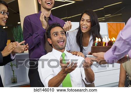 Hispanic co-workers surprising businessman with birthday cake View Large Photo Image Stock Image - Hispanic co-workers surprising businessman with birthday cake. Fotosearch