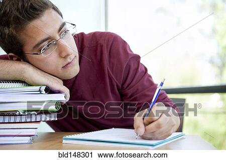 Stock Image - Hispanic college student doing homework. Fotosearch