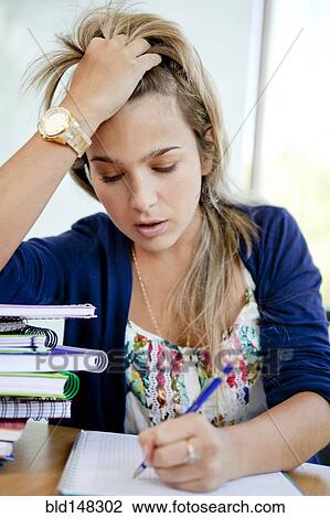 Stock Image - Hispanic college student doing homework. Fotosearch
