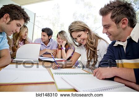 Stock Image - Hispanic college students doing homework. Fotosearch