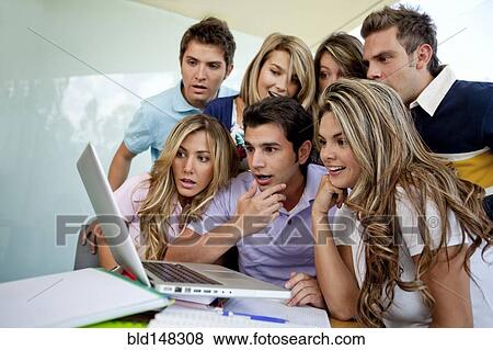 Stock Photo - Hispanic college students looking at laptop together. Fotosearch