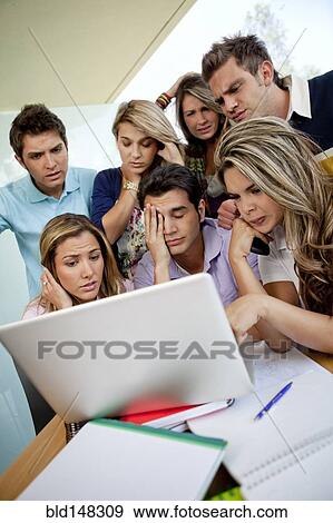 Stock Photo - Hispanic college students looking at laptop together. Fotosearch