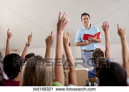 Hispanic college students raising arms in classroom View Large Photo Image Stock Image - Hispanic college students raising arms in classroom. Fotosearch