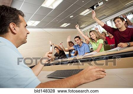 Hispanic college students raising arms in classroom View Large Photo Image Stock Photo - Hispanic college students raising arms in classroom. Fotosearch