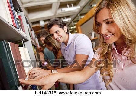Stock Photo - Hispanic college students studying together in library. Fotosearch