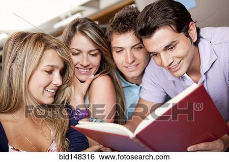 Stock Photograph - Hispanic college students studying together in library. Fotosearch