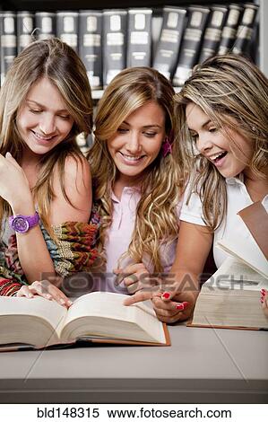 Stock Photography - Hispanic college students studying together in library. Fotosearch