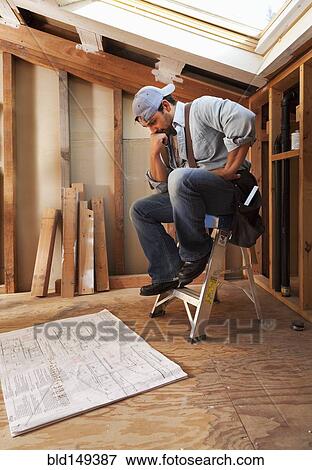 Hispanic construction worker looking at blueprints View Large Photo Image Stock Photo - Hispanic construction worker looking at blueprints. Fotosearch