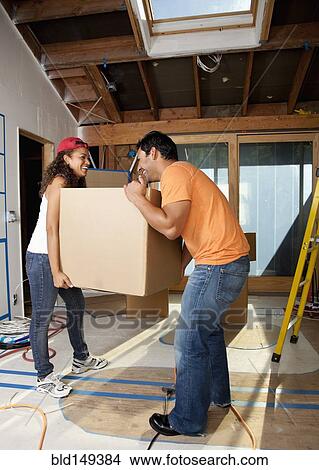 Picture - Hispanic couple carrying cardboard box. Fotosearch