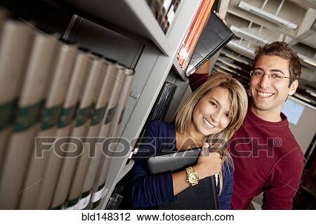 Hispanic couple standing together in library View Large Photo Image Stock Image - Hispanic couple standing together in library. Fotosearch