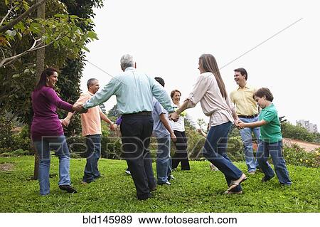 Stock Photo - Hispanic family holding hands in a circle outdoors. Fotosearch
