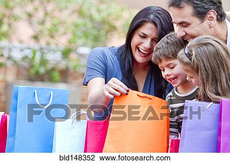 Hispanic family looking into shopping bags View Large Photo Image Stock Image - Hispanic family looking into shopping bags. Fotosearch