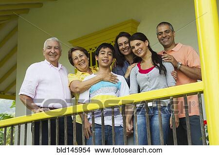 Picture - Hispanic family standing on porch together. Fotosearch