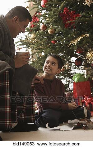 Hispanic father and son opening gifts Christmas morning View Large Photo Image Stock Image - Hispanic father and son opening gifts Christmas morning. Fotosearch