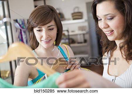 Stock Photography - Hispanic friends shopping in clothing store. Fotosearch