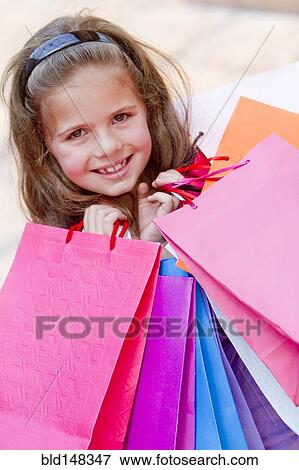 Hispanic girl carrying shopping bags View Large Photo Image Stock Photo - Hispanic girl carrying shopping bags. Fotosearch