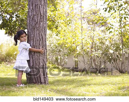 Hispanic girl hugging tree trunk View Large Photo Image Stock Image - Hispanic girl hugging tree trunk. Fotosearch