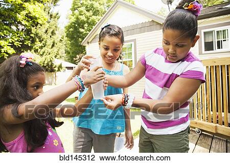 Hispanic girls examining water bottle View Large Photo Image Stock Image - Hispanic girls examining water bottle. Fotosearch
