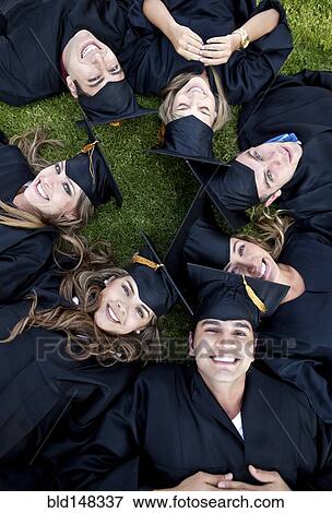 Hispanic graduates in caps and gowns laying in grass View Large Photo Image Stock Photo - Hispanic graduates in caps and gowns laying in grass. Fotosearch