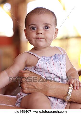 Stock Photo - Hispanic grandmother holding baby granddaughter. Fotosearch