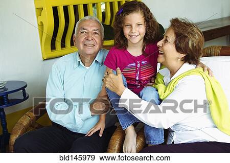 Stock Photo - Hispanic grandparents sitting with granddaughter. Fotosearch