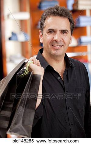 Hispanic man carrying shopping bags View Large Photo Image Stock Photography - Hispanic man carrying shopping bags. Fotosearch