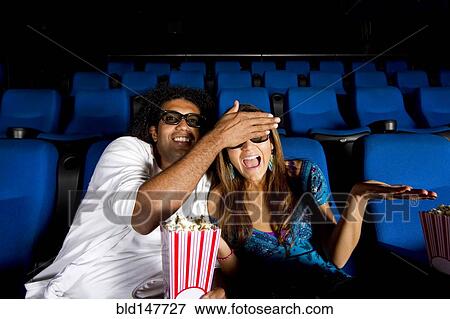Hispanic man covering girlfriend's eyes in movie theater View Large Photo Image Stock Photo - Hispanic man covering girlfriend's eyes in movie theater. Fotosearch