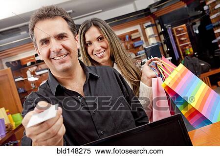 Hispanic man paying for shopping with credit card View Large Photo Image Stock Photography - Hispanic man paying for shopping with credit card. Fotosearch