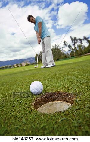 Hispanic man putting golf ball View Large Photo Image Stock Photo - Hispanic man putting golf ball. Fotosearch