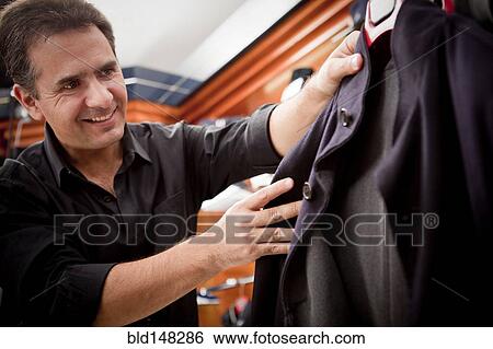 Hispanic man shopping for clothes in store View Large Photo Image Stock Photograph - Hispanic man shopping for clothes in store. Fotosearch