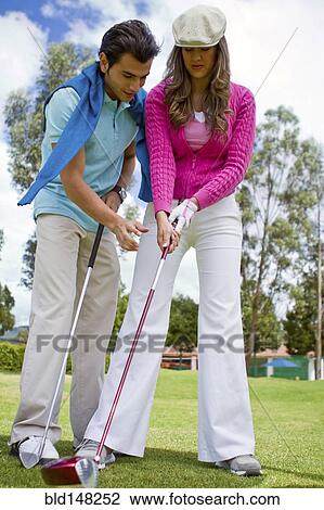 Hispanic man teaching girlfriend to play golf View Large Photo Image Stock Image - Hispanic man teaching girlfriend to play golf. Fotosearch