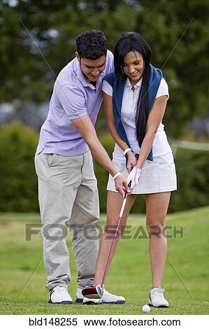 Hispanic man teaching girlfriend to play golf View Large Photo Image Stock Photography - Hispanic man teaching girlfriend to play golf. Fotosearch