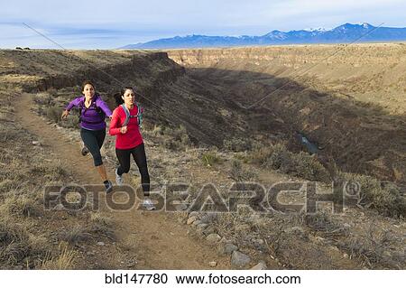 Stock Image - Hispanic runners training in remote area. Fotosearch