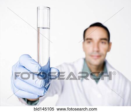 Stock Photography - Hispanic scientist holding test tube full of water. Fotosearch