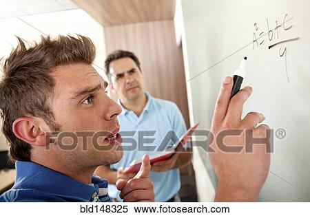 Hispanic teacher watching student writing on whiteboard View Large Photo Image Stock Photography - Hispanic teacher watching student writing on whiteboard. Fotosearch