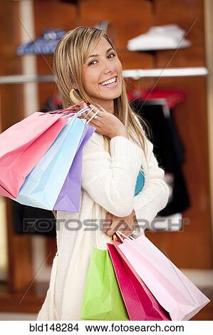 Picture - Hispanic woman carrying shopping bags. Fotosearch