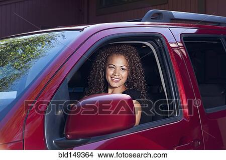 Hispanic woman driving red car View Large Photo Image Picture - Hispanic woman driving red car. Fotosearch