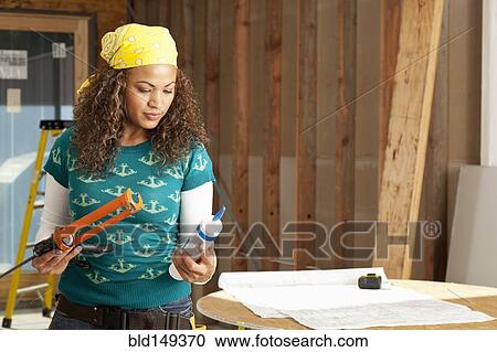 Hispanic woman holding caulking gun View Large Photo Image Stock Image - Hispanic woman holding caulking gun. Fotosearch
