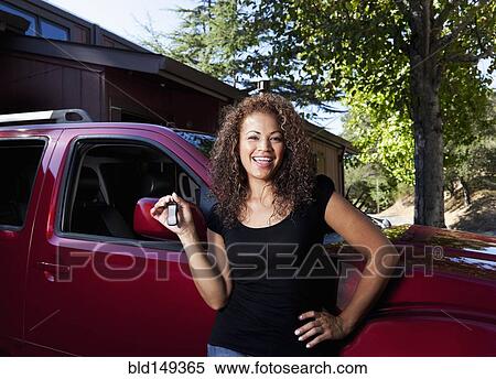 Stock Photography - Hispanic woman holding keys to new car. Fotosearch
