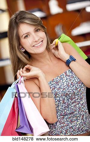 Stock Photo - Hispanic woman holding shopping bags. Fotosearch