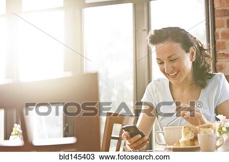 Hispanic woman in cafe using cell phone View Large Photo Image Stock Image - Hispanic woman in cafe using cell phone. Fotosearch
