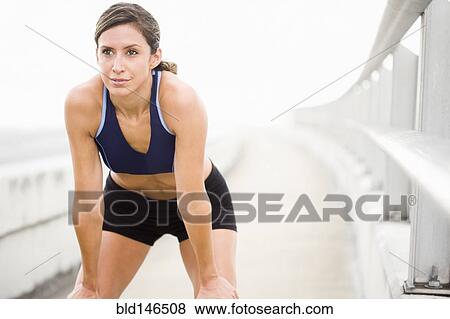Hispanic woman in sportswear resting on sidewalk View Large Photo Image Stock Photo - Hispanic woman in sportswear resting on sidewalk. Fotosearch