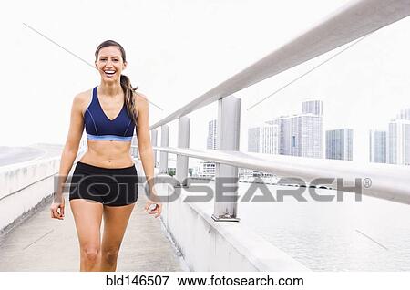 Hispanic woman in sportswear walking along urban waterfront View Large Photo Image Stock Photo - Hispanic woman in sportswear walking along urban waterfront. Fotosearch