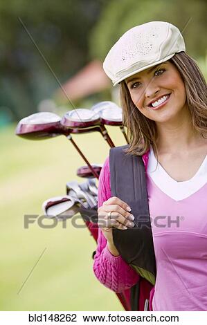 Stock Image - Hispanic woman playing golf. Fotosearch