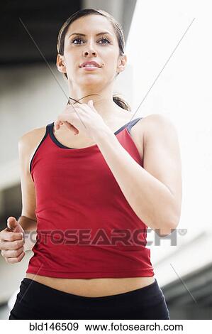 Stock Photo - Hispanic woman running in urban area. Fotosearch