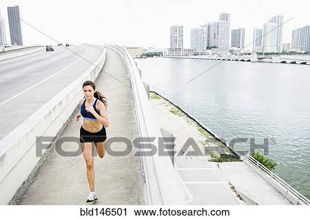 Hispanic woman running near urban waterfront View Large Photo Image Stock Image - Hispanic woman running near urban waterfront. Fotosearch