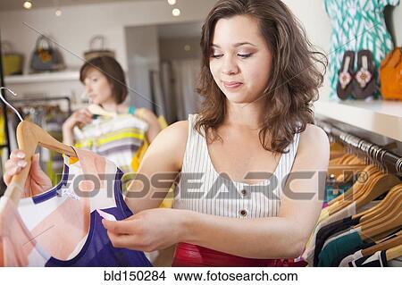 Hispanic woman shopping in clothing store View Large Photo Image Picture - Hispanic woman shopping in clothing store. Fotosearch